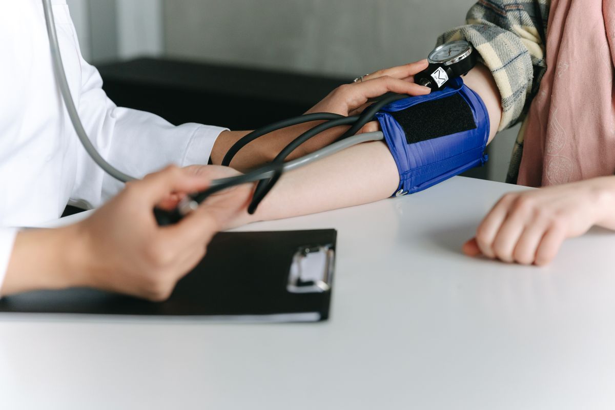 Healthcare worker checking a patient's blood pressure in a medical office
