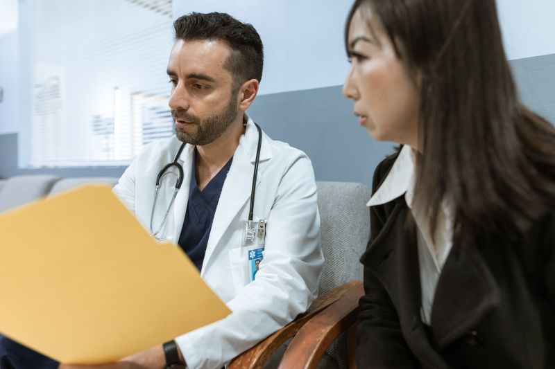Physician discussing health records with a patient in a clinical setting