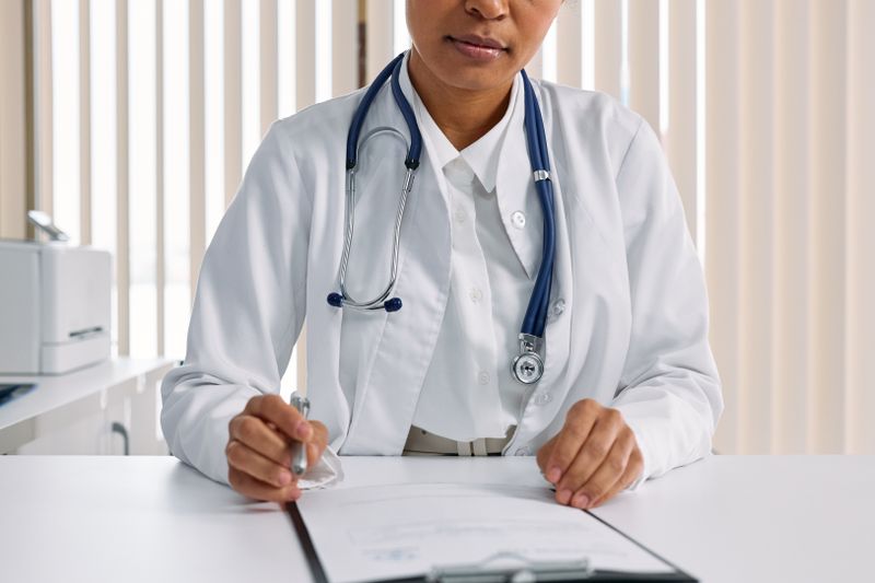 Portrait of Dr. Elena Marsh recording patient details in her office