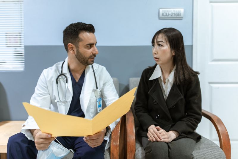 Portrait of Dr. Priya Nair consulting with a patient in a clinical setting