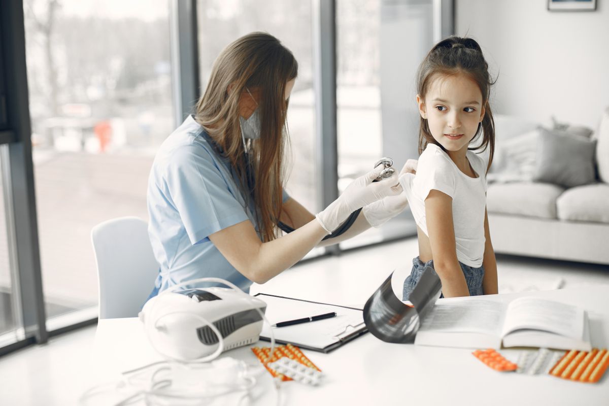 Young girl receiving a checkup from a pediatrician with a stethoscope